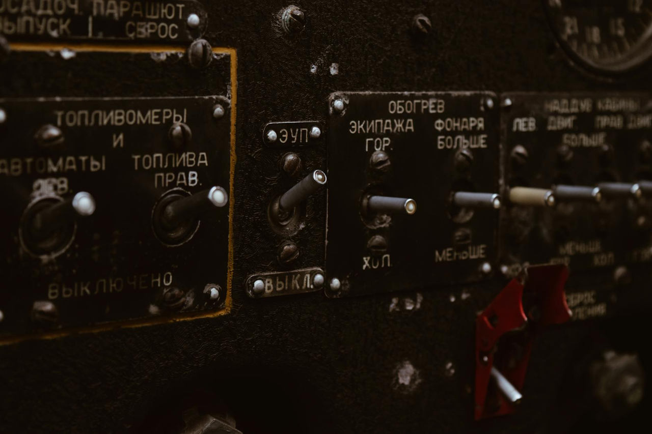 Close-up view of a vintage aircraft cockpit dashboard with Russian labels.
