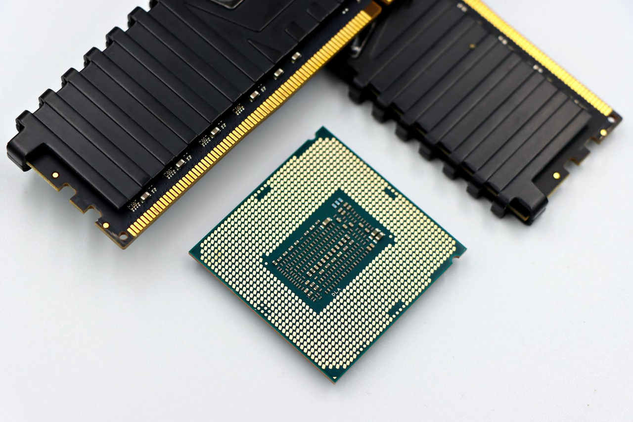 A CPU and RAM sticks displayed on a white surface, showcasing computer hardware components.